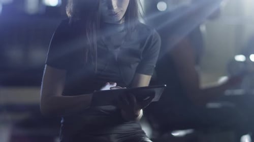 Attractive fit sporty woman is using a tablet computer in the gym.
