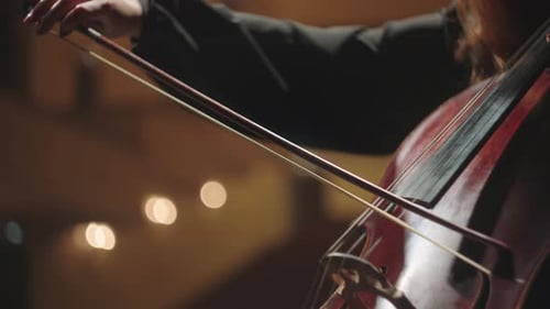 Cello Player Performing in Warmly Lit Venue