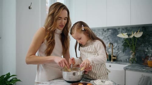 Woman and Girl Baking Together in a White Kitchen