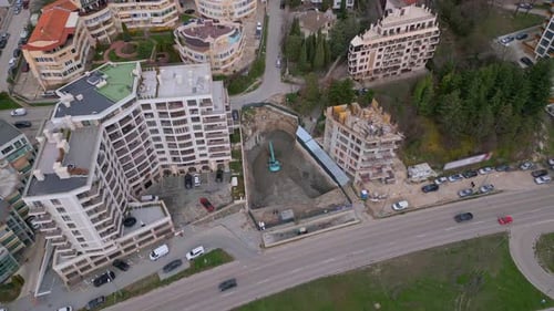 Una excavadora está cavando un pozo para la construcción de otro edificio en el centro de la ciudad
