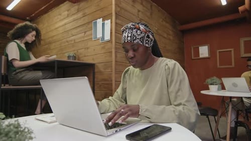 Freelance noire tapant sur un ordinateur portable en coworking