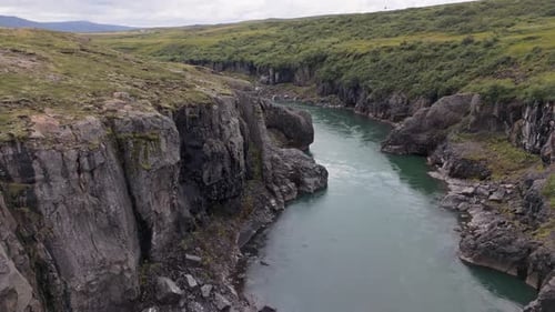Aerial View Of A Canyon In Iceland With A Mountain River Cutting Through It