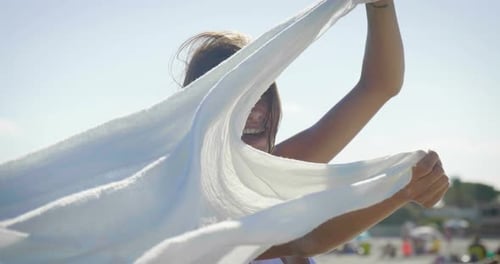 Portrait of a woman stands on a wooden pier in a white dress, looks at the sea feels free, backgro