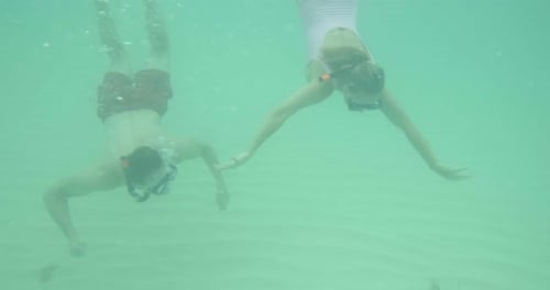 Man and Child Snorkeling Underwater