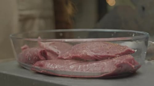 Seasoning Raw Beef Slices in Glass Bowl
