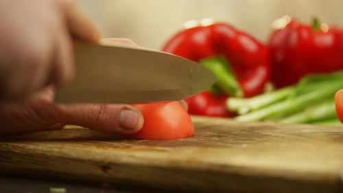 Tomato Being Sliced on a Cutting Board