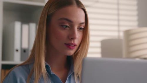 Woman Working on Laptop in Bright Home Office
