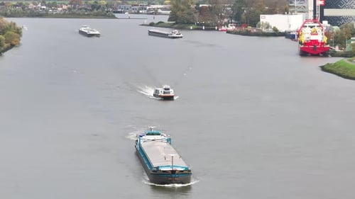 Numerous cargo vessels sailing on the River Noord, Ridderkerk, Netherlands