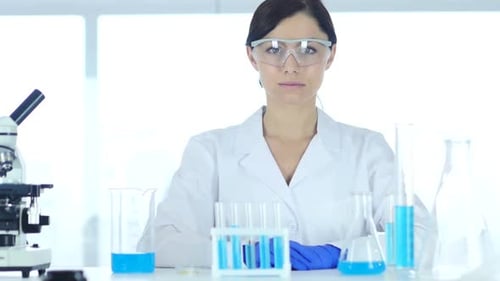 Reseach Scientist Sitting in Laboratory Looking at Camera