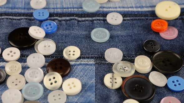 Plastic multi-colored buttons fall on denim. Slow motion., Slow Motion ...