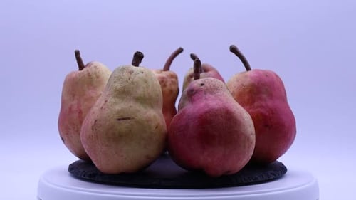 Frische reife rote Birne, die sich auf einem Drehteller dreht.