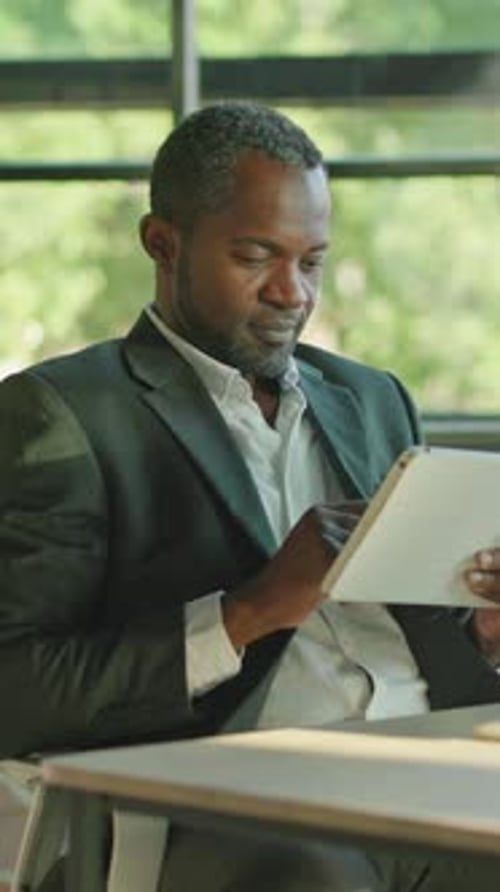 A Professional Man Diligently Working with a Tablet in a Modern Innovative Office Environment