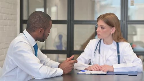 African Male Patient Talking with Female Doctor in Clinic