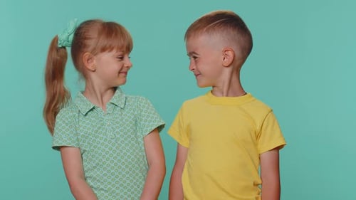 Brother and Sister Share Affectionate Hug on Teal Background