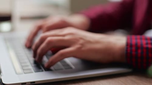 Nahaufnahme des Entwicklers von Freelancer beim Coworking beim Tippen von Programmcode auf der Laptop-Tastatur