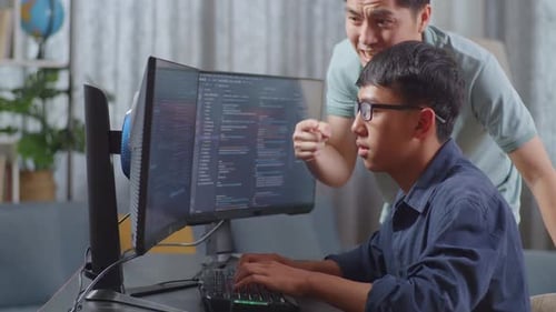 Pai asiático gritando com seu filho enquanto criava um engenheiro de software desenvolvendo aplicativo e programa