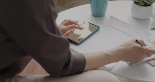 Woman Using Calculator App for Finance at Home