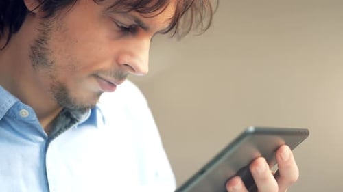 4k video footage of a young businessman using a digital tablet while working in a cafe