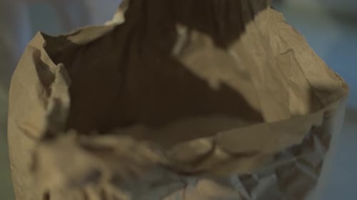 Close up, following hand holding a shovel, baker processing creation of bread, adding flour from a p