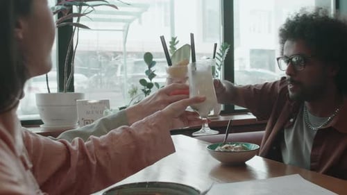Group of Multi-ethnic Friends Having Dinner and Toasting in Cafe