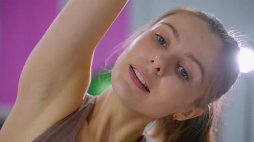 CloseUp of Woman Stretching During Fitness Workout with Bright Gym Lights