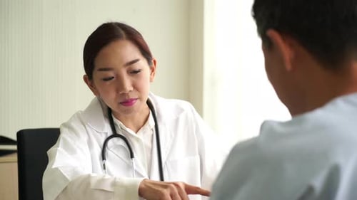 Doctor Explains Treatment to Patient in Hospital Office