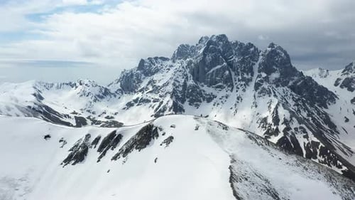Breathtaking rotating drone shot of the snow covered Georgian Dolomites in the Caucasus mountains in