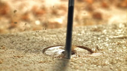 Un carpintero perfora un agujero en un producto de madera filmado con una cámara de alta velocidad a 1000 fps