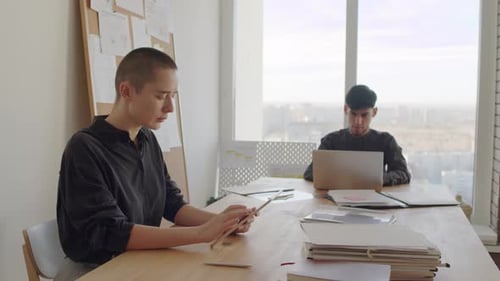 People Working on Digital Devices in Bright Office