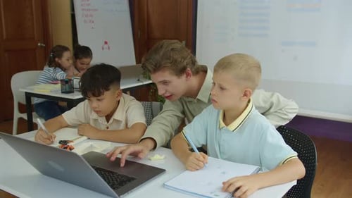 Instructor Helping Students with Technology in Classroom