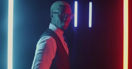 Slow Motion of Young African American Businessman Turning to Camera and Smiling in Dark Neon