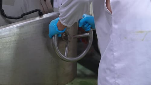 Un homme caucasien et une travailleuse afro-américaine portant une blouse de laboratoire vérifiant une tablette numérique.