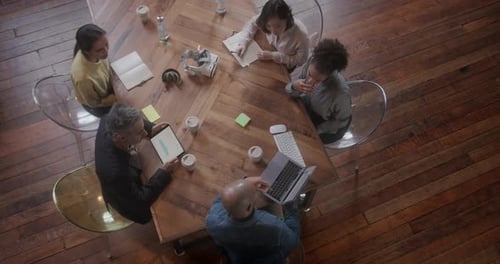 Overhead View on Business People in Meeting with Technology at Creative Office