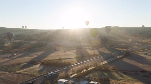 Hot Air Balloons Float Over Rural Landscape at Sunrise