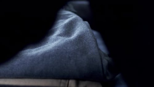 Hands Packing Clothing into Suitcase for Travel