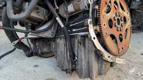 Car engine components exposed in repair shop daylight view