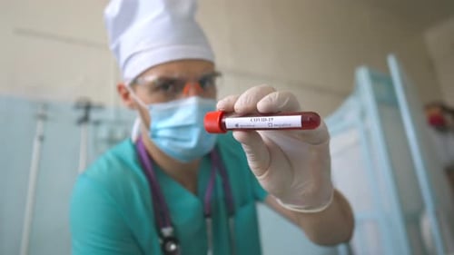 Doctor Holding COVID-19 Blood Sample in Hospital