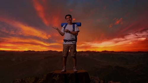 Asian Male Smiling And Pointing To Side On Top Mountain