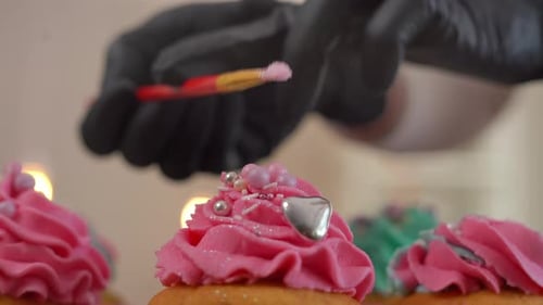 Baker Decorating Delicious Cupcakes with Pink Frosting