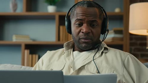 Man Talking on Laptop in Home Office