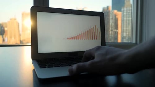 Laptop Displaying Charts by City Window