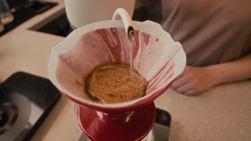 Pouring Water Over Coffee Grounds in Filter Close Up
