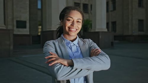 Businesswoman Smiling Outdoors in Corporate Attire Near Modern Building
