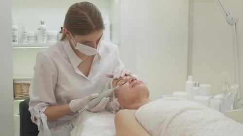 Woman Receiving Facial Treatment in Bright White Room