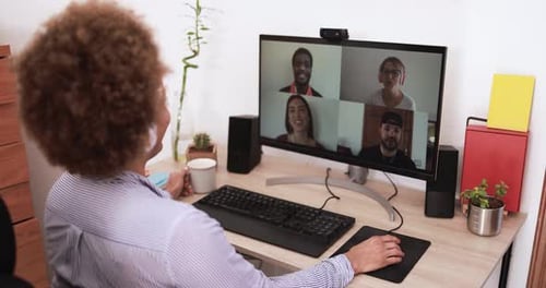 Woman video conferencing with colleagues at desk