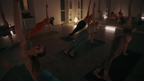 Women Doing Yoga in a Dimly Lit Studio