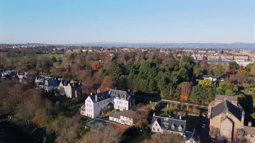 Drone Footage Over Edinburgh Residential Area with View of Distant City and Coastline
