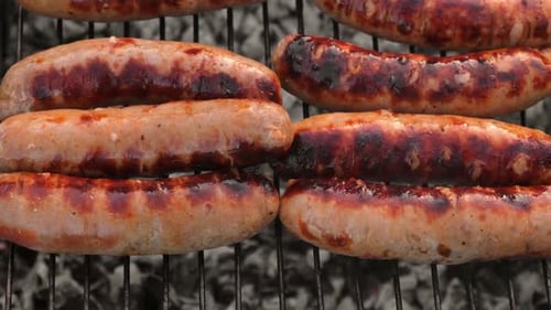 Grillwürste, Koch, Mann, bereitet Grillgut zu, Barbecue mit Rauchflamme, im Freien, lecker, saftig