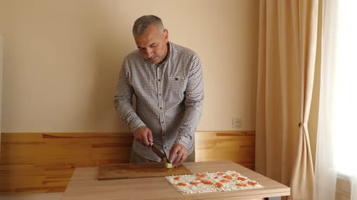 Man Prepares Food at a Table Indoors