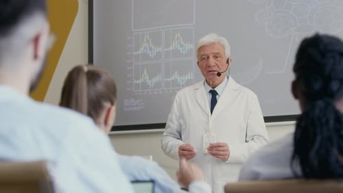 Senior Male Presenter Answering Colleagues Question during Medical Conference